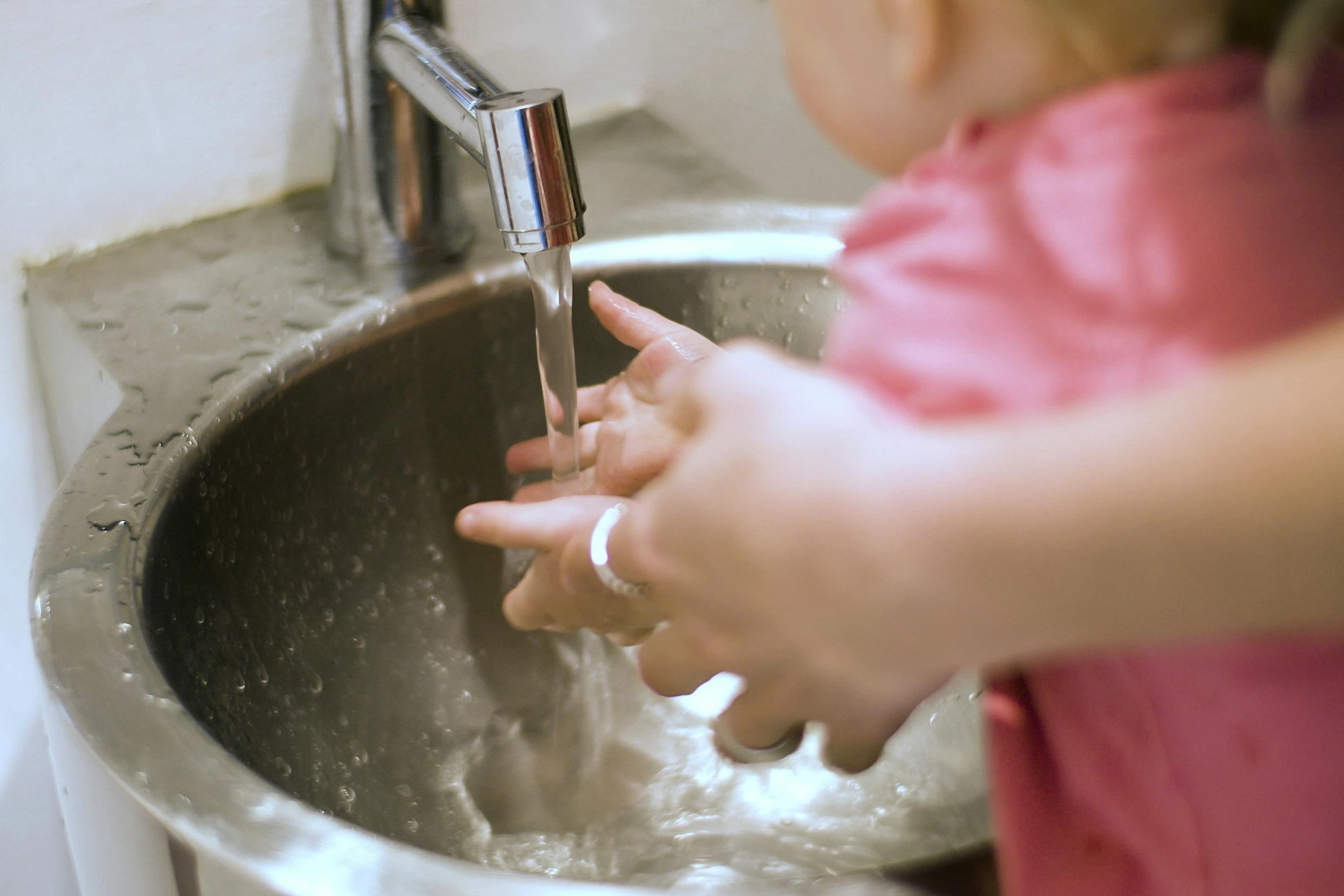 a little girl washing her hands in a sink, by Arabella Rankin, pexels, stainless steel, where a large, thumbnail, screensaver