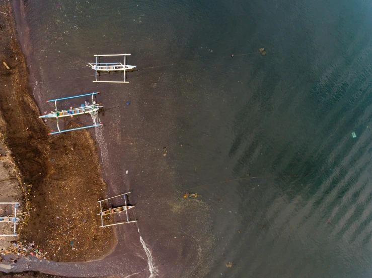 a group of boats sitting on top of a sandy beach, by Attila Meszlenyi, pexels contest winner, dau-al-set, satellite imagery, bali, sunken, near a jetty