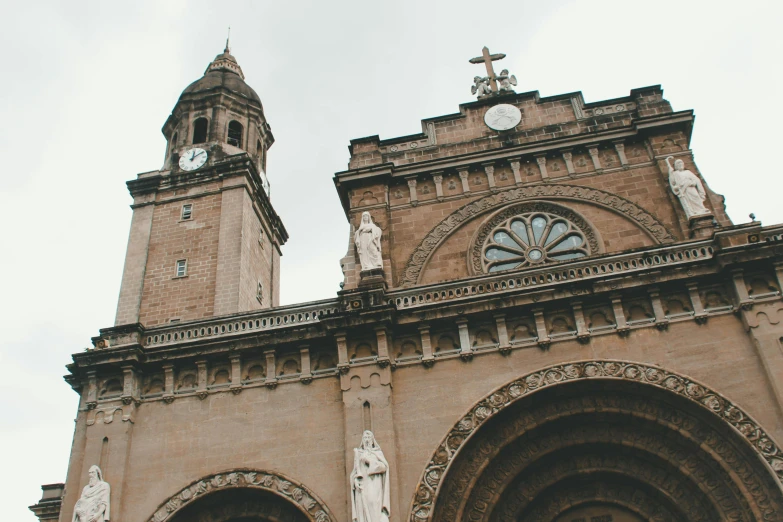 a couple of people standing in front of a church, by Matteo Pérez, pexels contest winner, art nouveau, neoclassical tower with dome, brown, freddy mamani silvestre facade, philippines