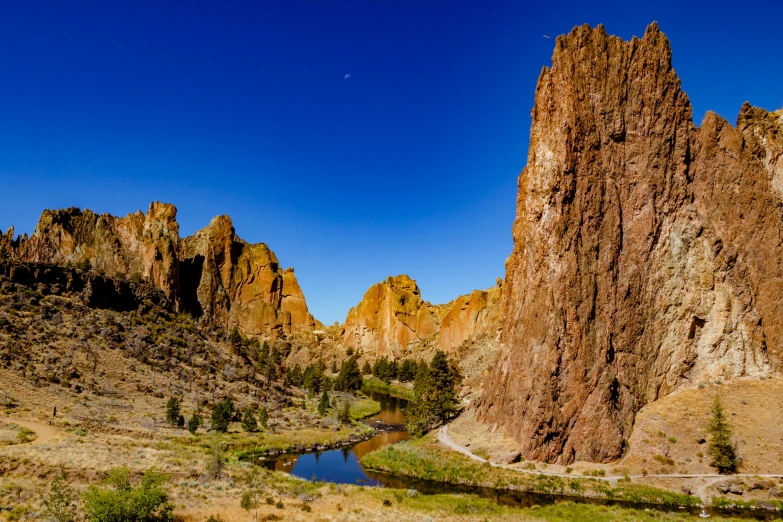 a river running through a lush green valley, a photo, by Jim Nelson, pexels contest winner, art nouveau, tall stone spires, black mesa, square, brown