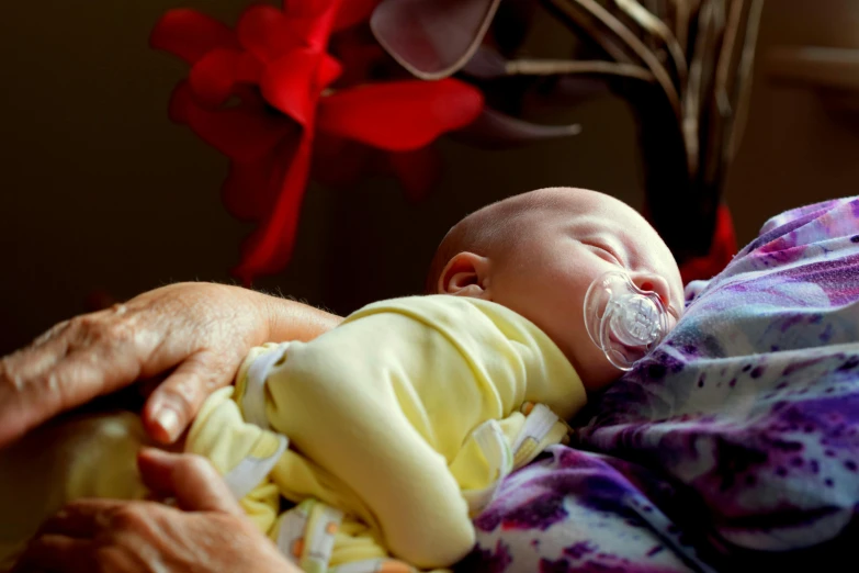 a close up of a person holding a baby, resting, vibrant setting, thumbnail, anaesthetic