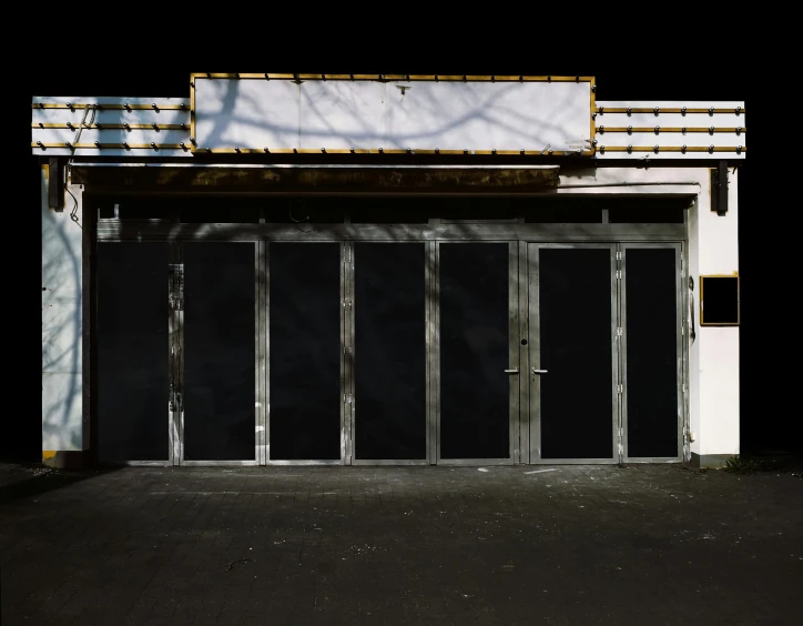 a fire hydrant sitting in front of a building, an album cover, by Jan Rustem, bauhaus, abandoned mall at night, black background hyperrealism, doors, photo of the cinema screen