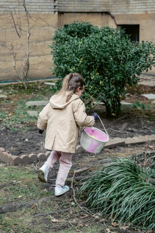 a little girl that is holding a bucket, inspired by Beatrix Potter, pexels contest winner, walking at the garden, wearing a pastel pink hoodie, digging, schools