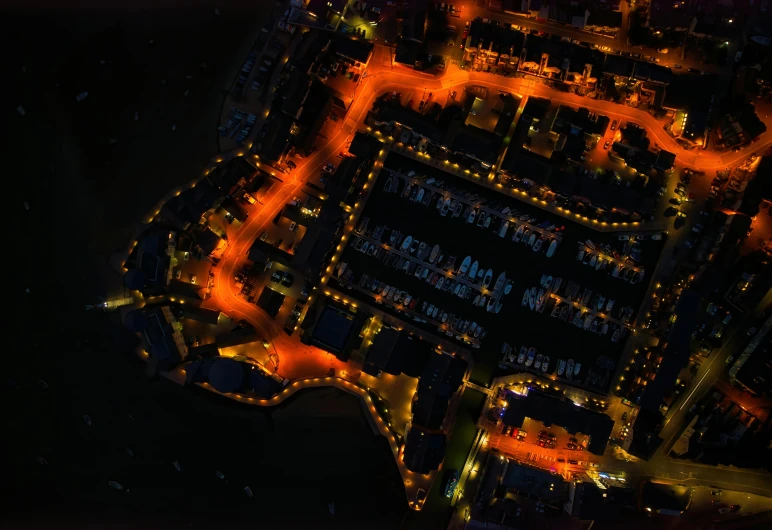 an aerial view of a city at night, pexels, digital art, victorian harbour night, 8 k. volumetric lighting. dark, orange lights, coastal