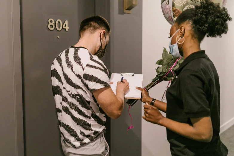 a couple of people standing in front of a door, signing a bill, tyler miles lockett, non-binary, bouquet