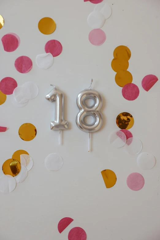 a close up of a birthday cake with confetti, inspired by Christen Købke, unsplash, satin silver, golden number, 1 8, floating lanterns