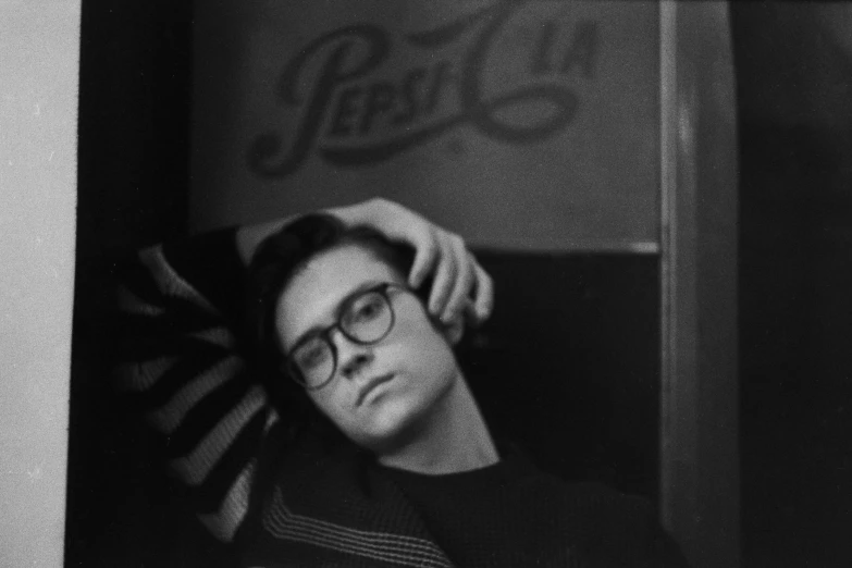 a black and white photo of a man with glasses, a black and white photo, inspired by Max Gubler, pepsi, in her early 20s, vintage aesthetic, joe keery