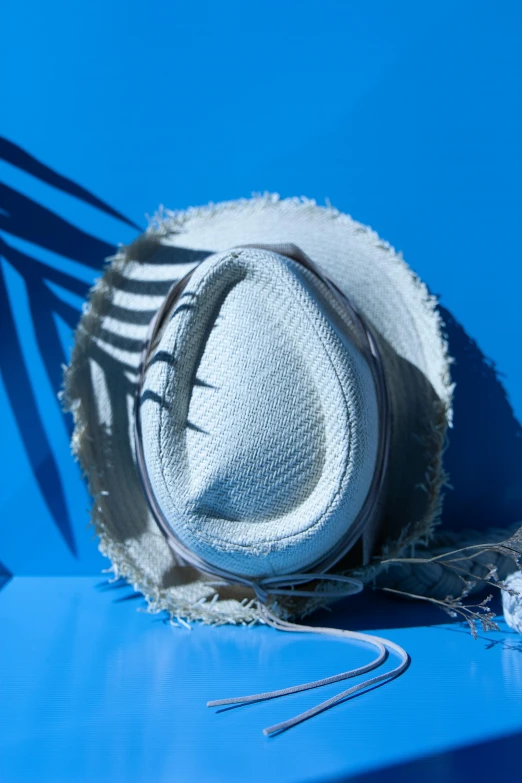 a white hat sitting on top of a blue bench, an album cover, by Peter Alexander Hay, unsplash, subject made of white mesh rope, shattered visor, detail shot, back lit