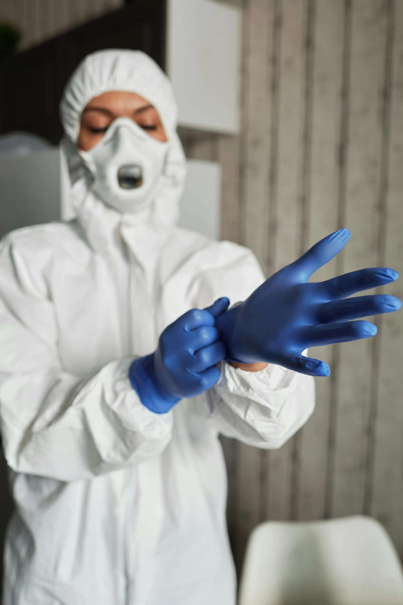 a man in a white hazmat suit and blue gloves, a portrait, by Adam Marczyński, shutterstock, plasticien, partially cupping her hands, instagram photo, fabric, detailed surroundings