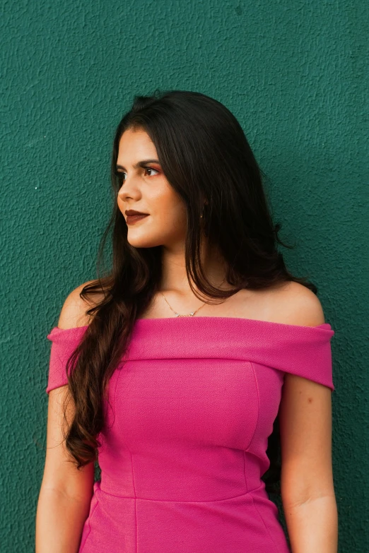 a woman in a pink dress leaning against a green wall, by Amelia Peláez, pexels contest winner, long dark hair, 18 years old, promotional image, headshot profile picture