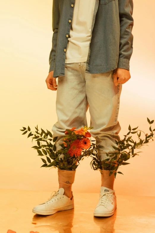 a man standing next to a bunch of flowers, an album cover, inspired by jeonseok lee, photorealism, worn pants, uncropped, pose 4 of 1 6, loosely cropped