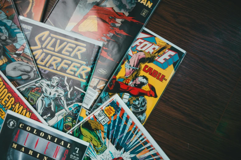 a pile of comic books sitting on top of a table, movie posters, retro science fiction, flatlay book collection, torrent