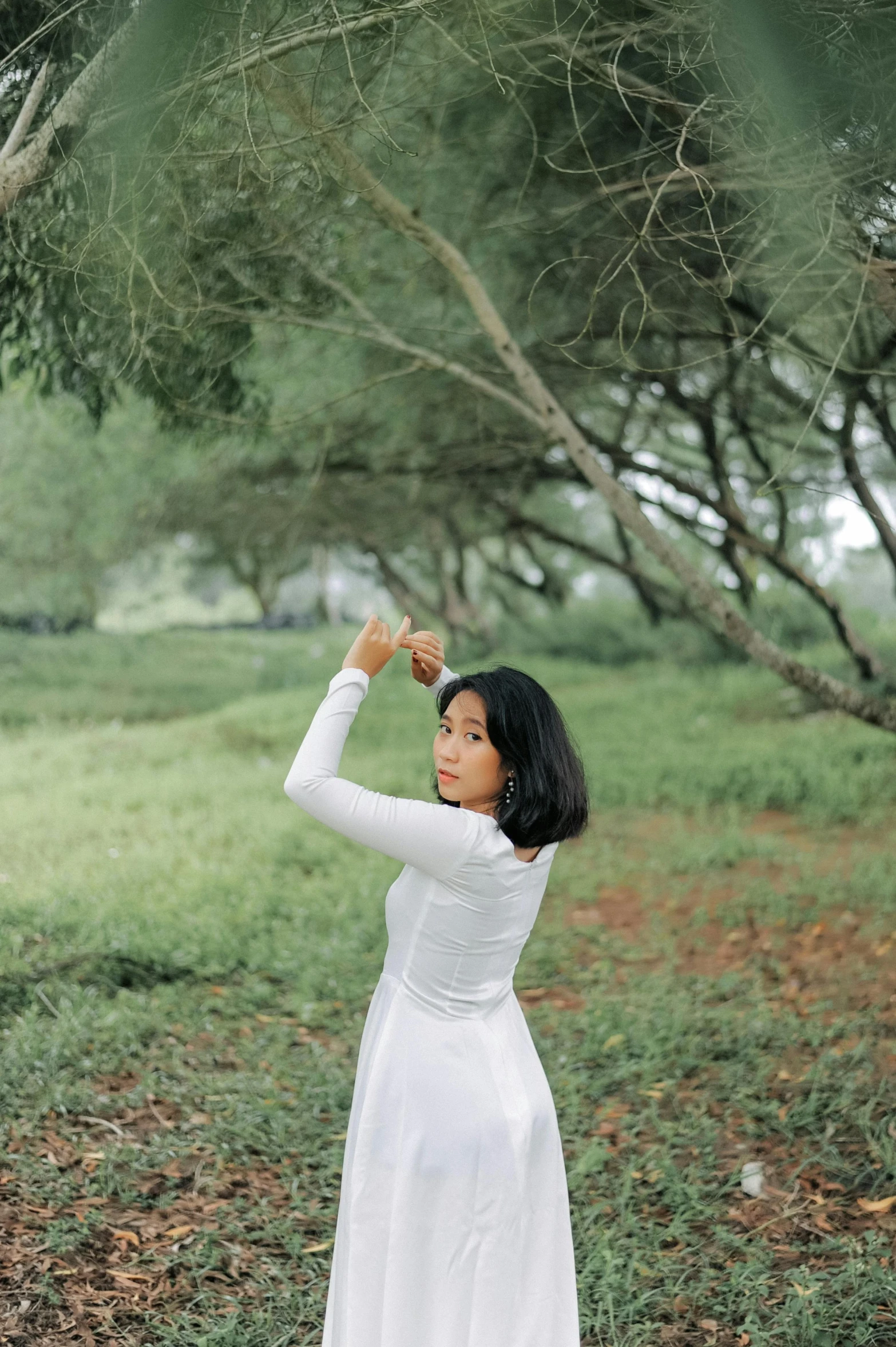 a woman in a white dress standing in a field, by Tan Ting-pho, unsplash, realism, on a branch, low quality photo, casual pose, indonesia