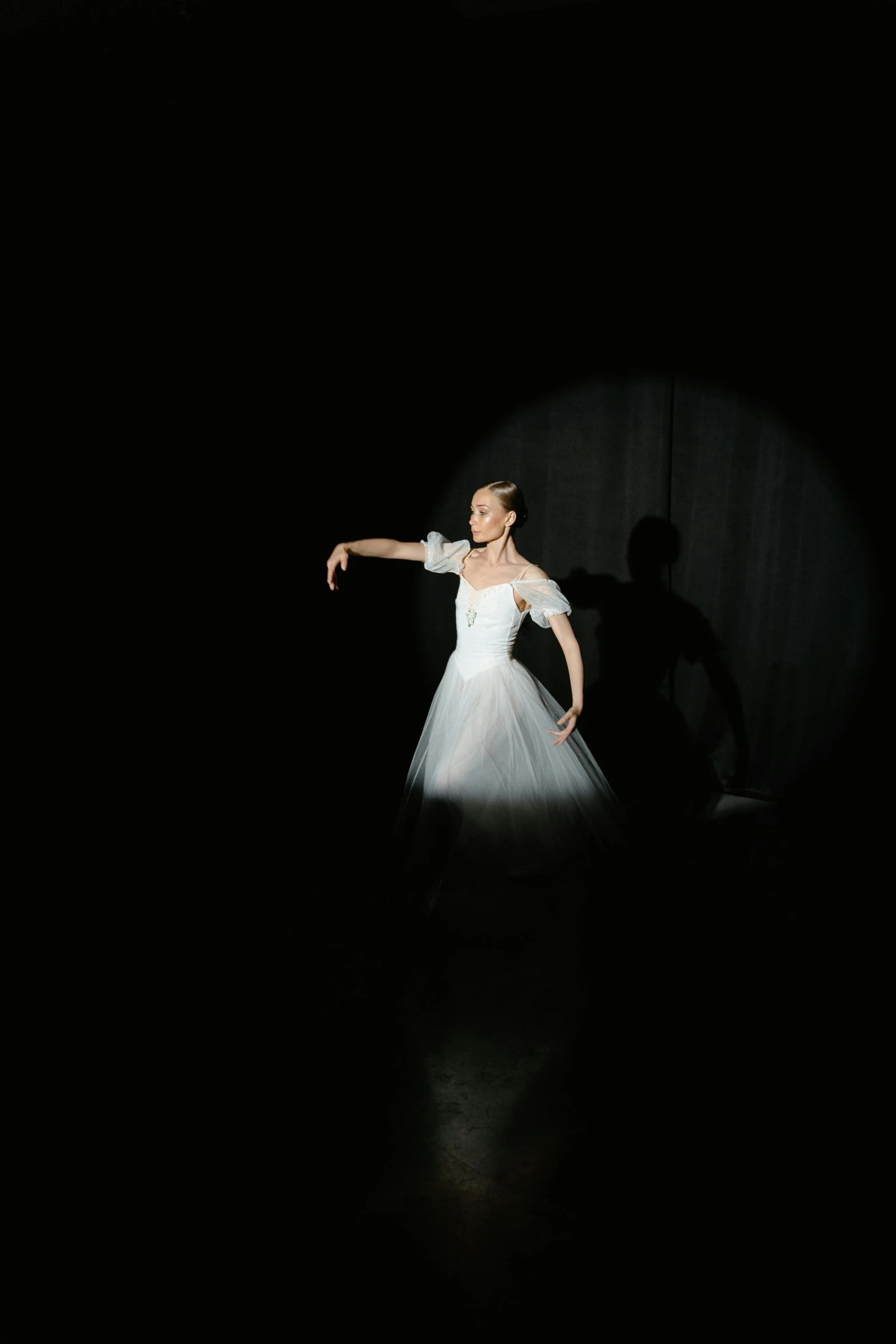 a woman in a white dress standing in the dark, a hologram, by Elizabeth Polunin, unsplash, arabesque, high quality photo, mariko mori, slide show, dressed as a ballerina