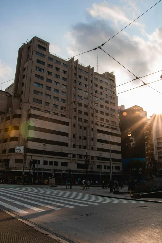 a person riding a skateboard on a city street, unsplash, quito school, brutalist office buildings, sun down, intersection, buenos aires