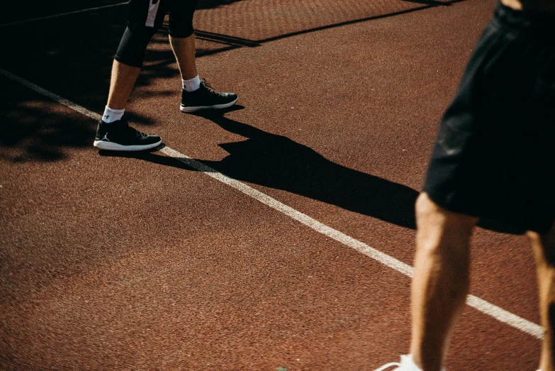 a couple of people standing on top of a tennis court, pexels contest winner, running shoes, thick black lines, shaded, running sequence