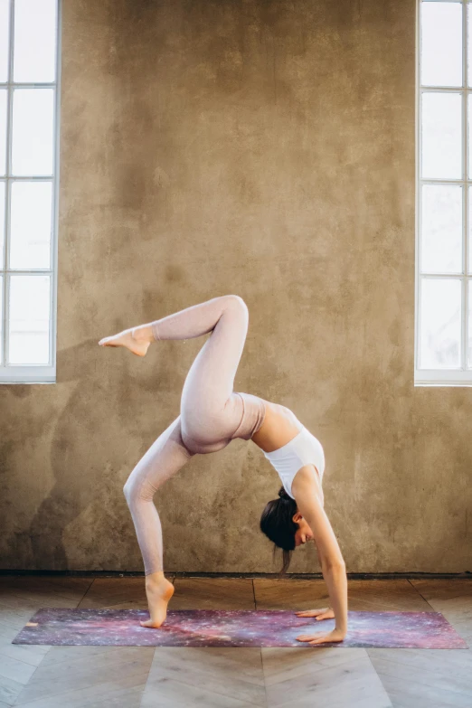 a woman doing a handstand on a yoga mat, pexels contest winner, arabesque, white sweeping arches, arched ceiling, vintage glow, gif