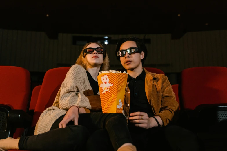 a man and a woman sitting in a movie theater, trending on pexels, hyperrealism, wearing orange sunglasses, avatar image, lesbians, cinematic. by leng jun