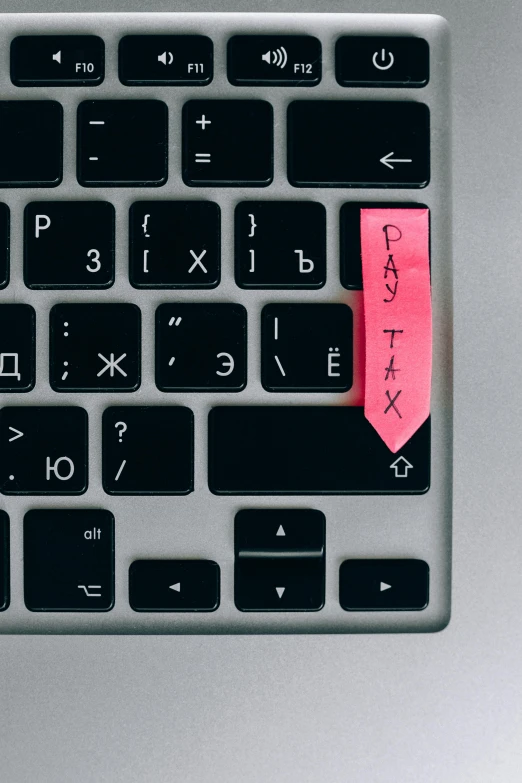 a close up of a keyboard with a sticky note on it, by Adam Rex, pexels, sovietwave aesthetic, pink, currency symbols printed, tag