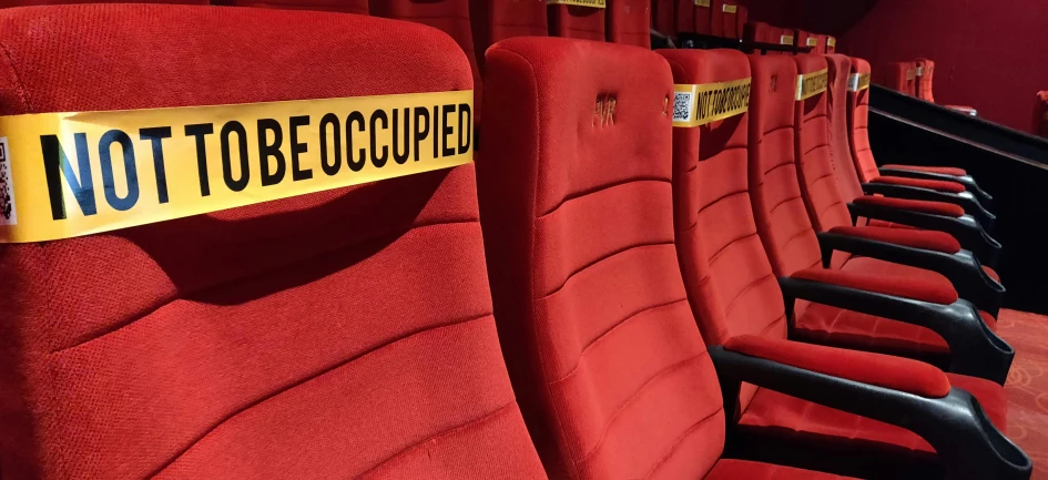 a row of red seats sitting next to each other, a photo, excessivism, kill bill, half - occupied with people, labeled, obscured