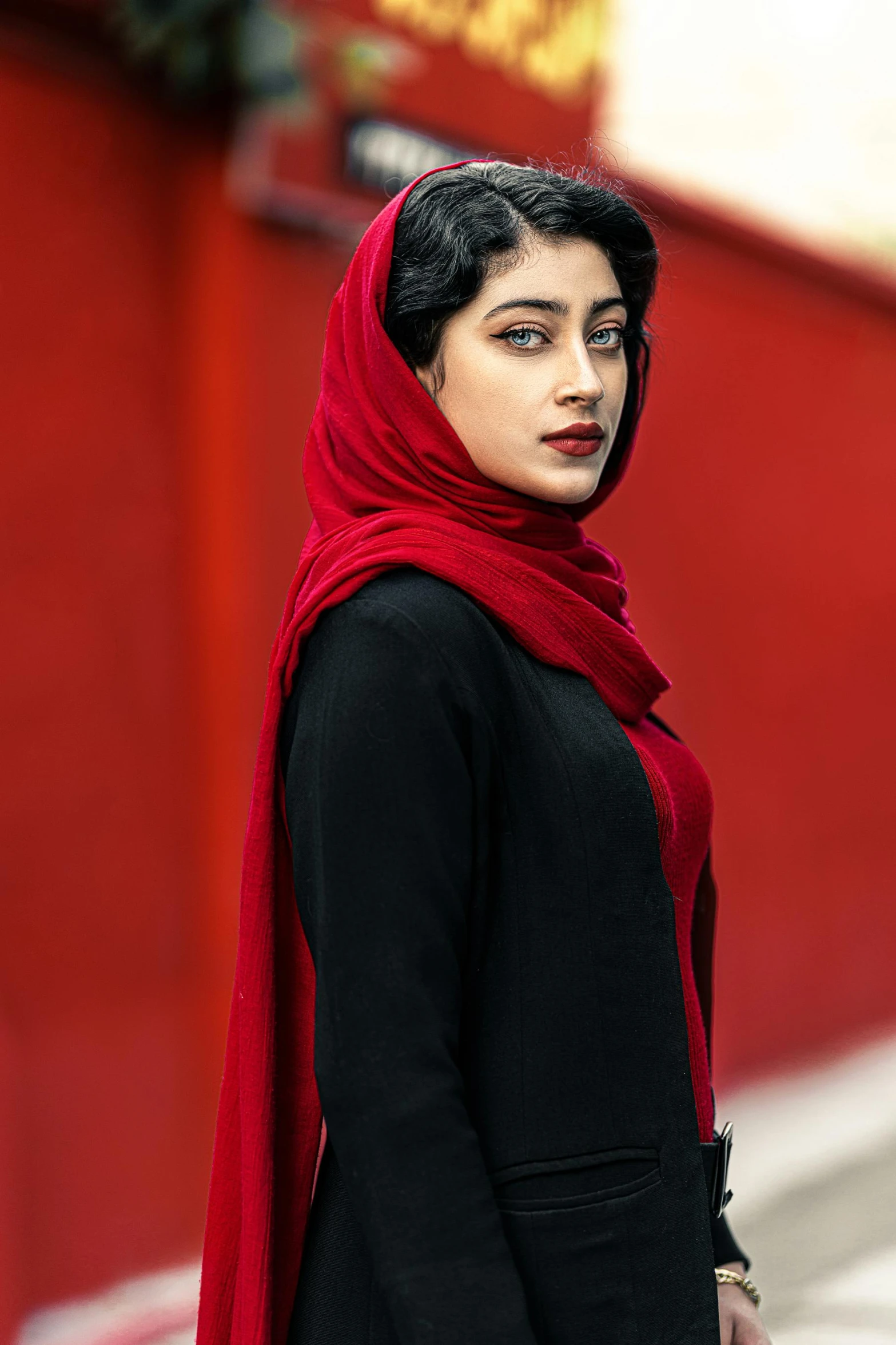 a woman in a black dress and a red scarf, inspired by Maryam Hashemi, trending on pexels, iran, square, female model, pale red