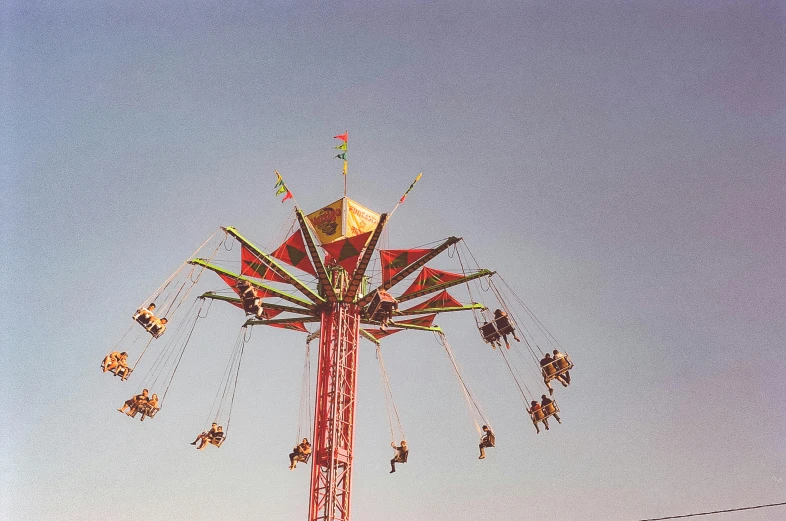 a group of people riding on top of a carnival ride, a colorized photo, pexels contest winner, hurufiyya, photo taken on fujifilm superia, swings, tall metal towers, instagram post