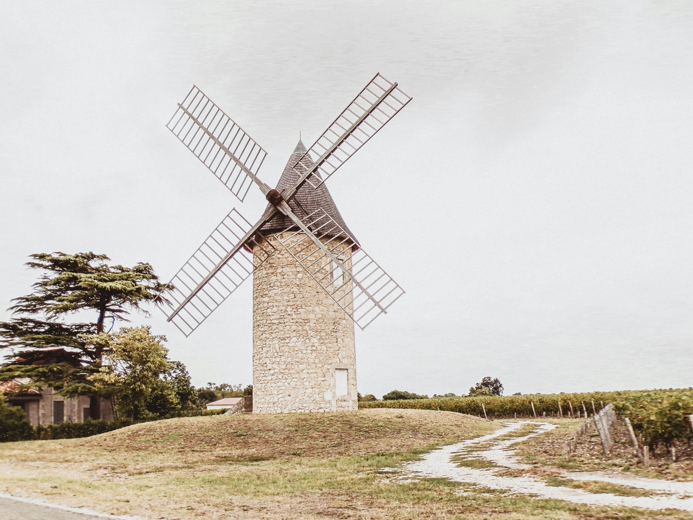 a windmill sitting on top of a lush green field, an album cover, by Raphaël Collin, pexels contest winner, renaissance, french village exterior, limestone, profile image, listing image