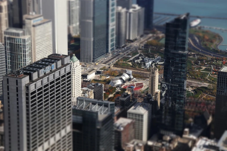 a view of a city with lots of tall buildings, a tilt shift photo, pexels contest winner, photorealism, chicago, calatrava, ignant, helipad