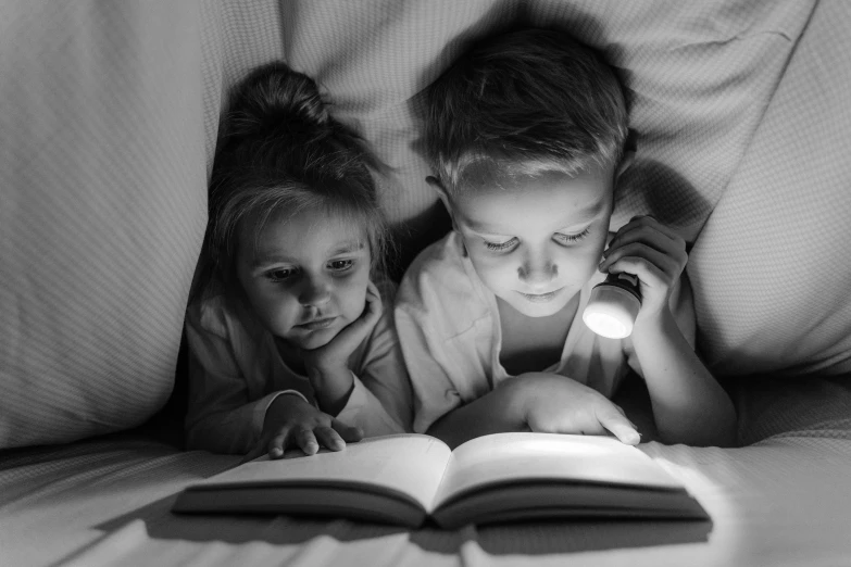 a black and white photo of two children reading a book, night light, 15081959 21121991 01012000 4k, featured, illustration »