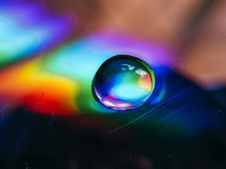 a close up of a water drop on a cell phone, inspired by Gabriel Dawe, trending on pexels, holography, muted rainbow tubing, instagram post, multi - coloured, mother of pearl iridescent