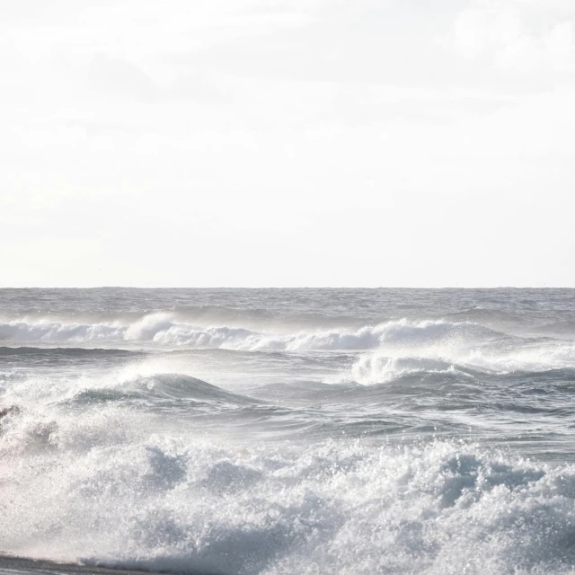 a man riding a wave on top of a surfboard, pexels contest winner, minimalism, waves crashing in the sea, grey, coastline, ( ( ( ( kauai ) ) ) )