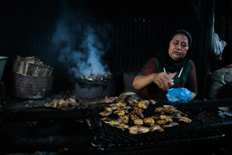 a woman is cooking food on a grill, a portrait, by Meredith Dillman, pexels contest winner, hurufiyya, world press photo, grilled chicken, market setting, reza afshar
