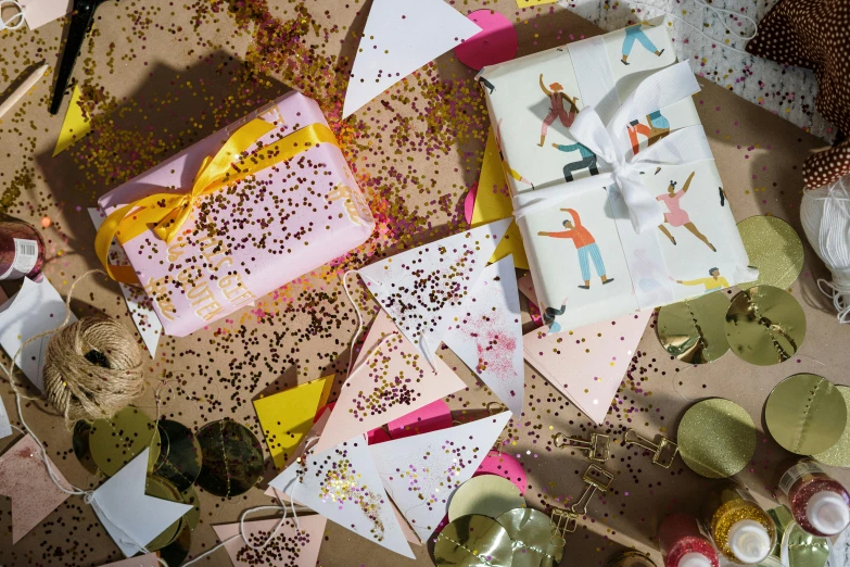 a table topped with lots of cards and confetti, by Julia Pishtar, pink and yellow, packaging, miscellaneous objects, holiday