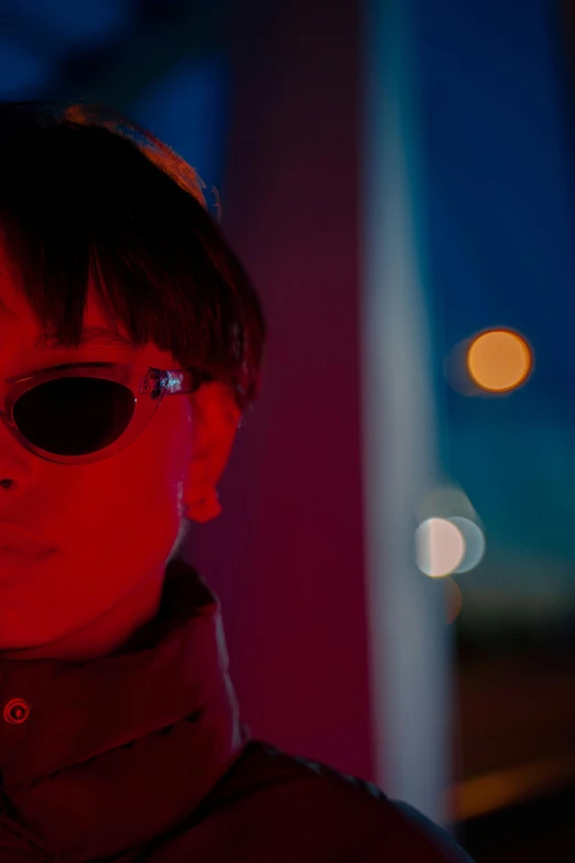 a close up of a person wearing sunglasses, inspired by Liam Wong, red lighting, ( ( theatrical ) ), large shot, ultraviolet