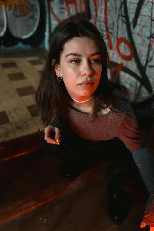 a woman sitting on the ground next to a fire hydrant, an album cover, inspired by Elsa Bleda, trending on pexels, antipodeans, wearing a native american choker, complex lights, as she looks up at the ceiling, close up portrait photo