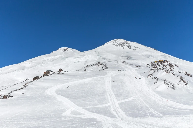 a man riding a snowboard down the side of a snow covered slope, hurufiyya, seen from afar, clear blue skies, nekro petros afshar, seen from a distance