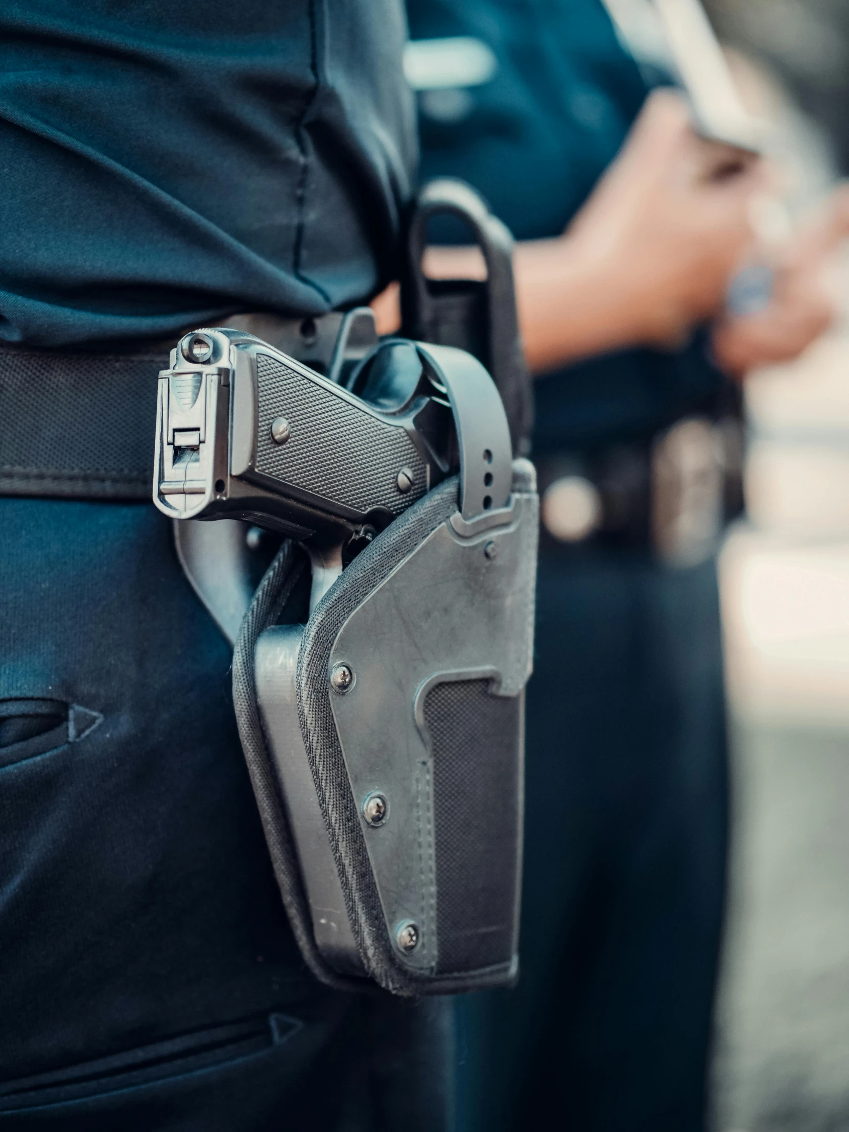 two police officers standing next to each other, unsplash, pistol in holster, closeup photograph, profile image