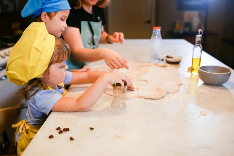 a woman and two children making cookies in a kitchen, pexels contest winner, sandro botticelli style, chef table, reverse, brown