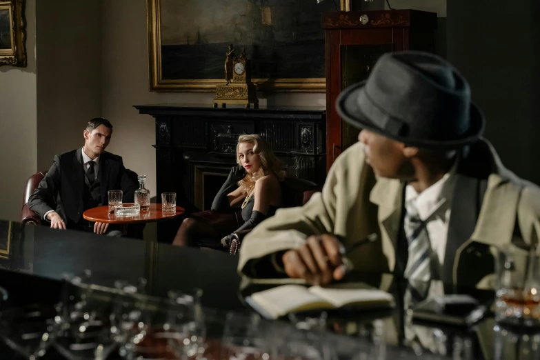 a group of people sitting around a bar, by David Donaldson, pexels, renaissance, portrait of a detective, behind the scenes photo, high quality image, sitting in a lounge