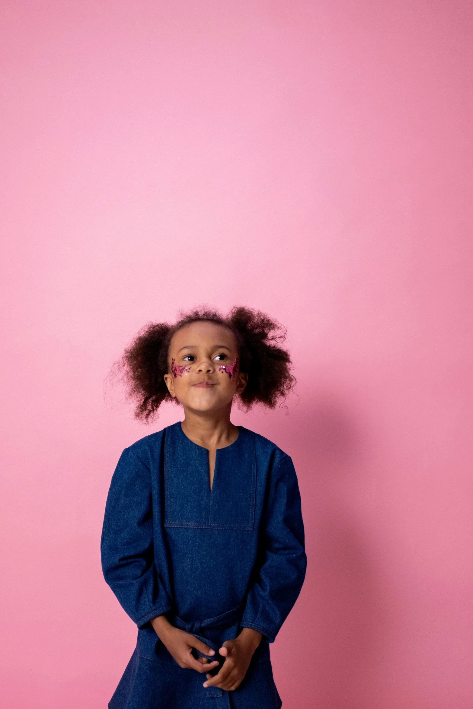 a little girl standing in front of a pink wall, by Lily Delissa Joseph, funny faces, blue and pink shift, ( ( dark skin ) ), highresolution