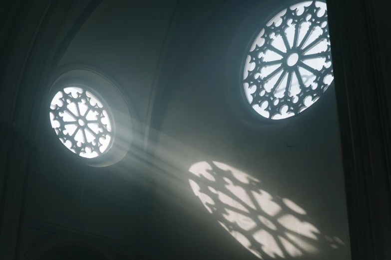 the sun shines through the windows of a cathedral, a raytraced image, by Adam Marczyński, light and space, window lights, round windows, moody hazy lighting, unrealengine octane render