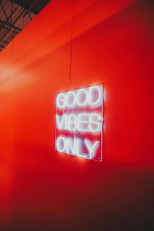 a neon sign hanging from the side of a wall, trending on pexels, minimalism, good vibes, red room, really good vibes, good vibrations