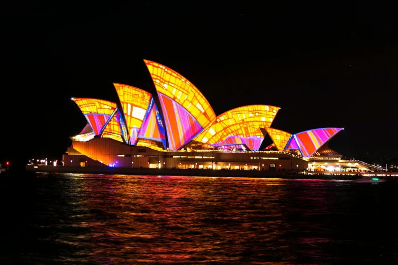 the sydney opera house lit up at night, a hologram, pexels contest winner, art nouveau, pink and orange neon lights, colorful”