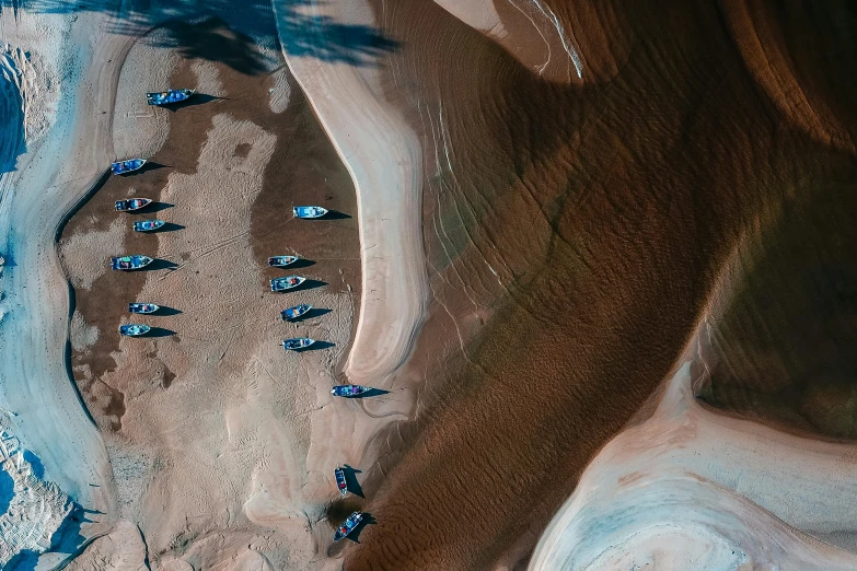 a group of boats sitting on top of a sandy beach, pexels contest winner, land art, chocolate river, satellite imagery, thumbnail, australian desert