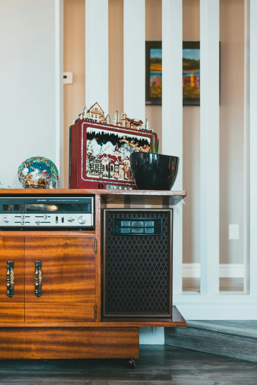 a wooden entertainment center sitting on top of a hard wood floor, an album cover, folk art, radios, home display, speakers, king