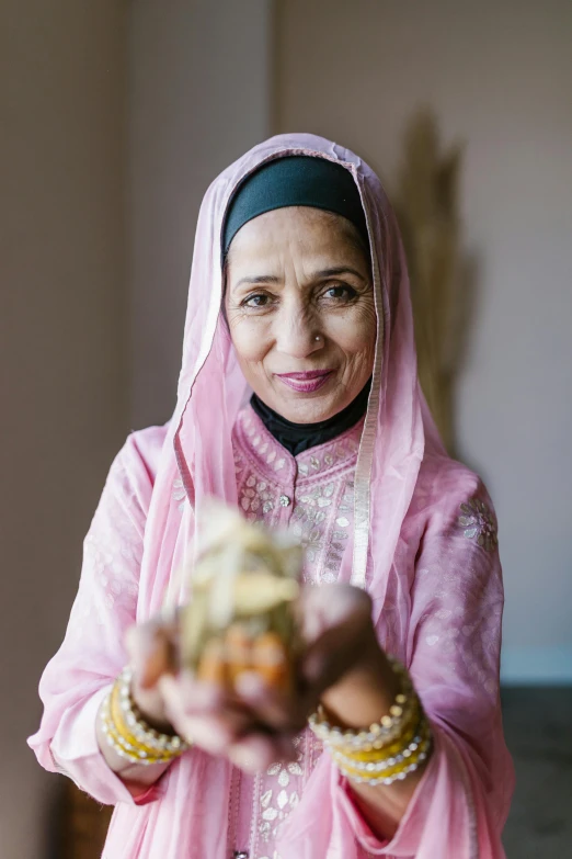 a woman holding a piece of food in her hands, a portrait, inspired by Nazmi Ziya Güran, hurufiyya, profile image