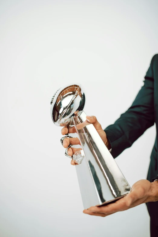 a man in a suit holding a trophy, superbowl, with a sleek spoiler, levers, sports illustrated