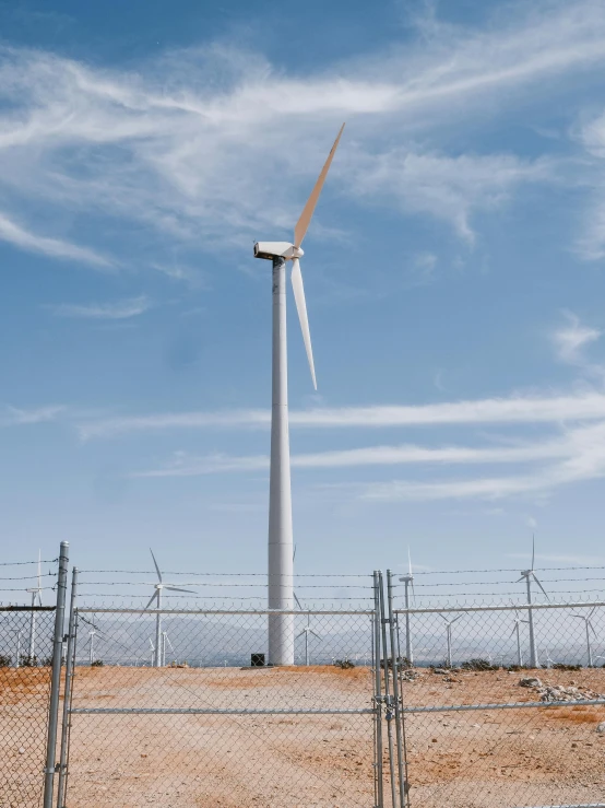 a wind turbine behind a chain link fence, unsplash contest winner, unimaginably huge, 4 k cinematic still, high quality product image”