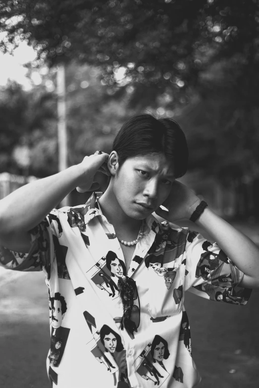 a black and white photo of a man smoking a cigarette, inspired by Gang Se-hwang, with hawaiian shirt, around 1 9 years old, steven jung, with shoulder pads