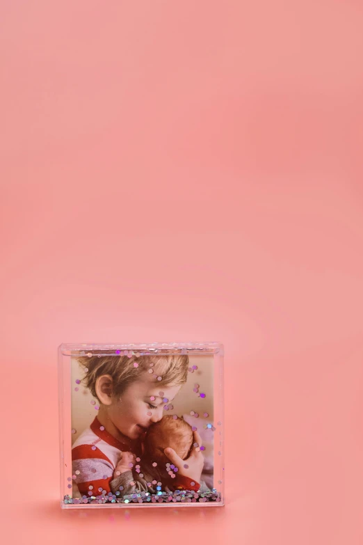 a couple on a pink background with confetti sprinkles, a picture, photorealism, dreamscape in a jar, holographic case display, amber, photo of the girl
